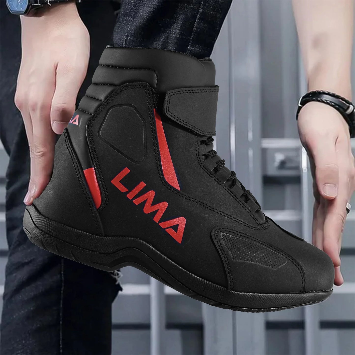 Black and red LIMA sports riding boot with laces, worn by person in casual jeans.